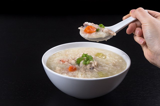 Pressure Cooker (Instant Pot) Turkey Rice Porridge in a white bowl with a spoonful of soup above it