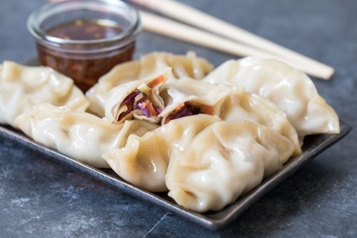 A tray of food on a plate, with Steamed dumplings