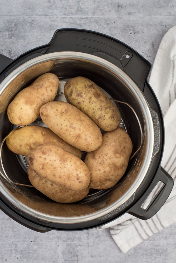 instant pot with several large baking potatoes inside