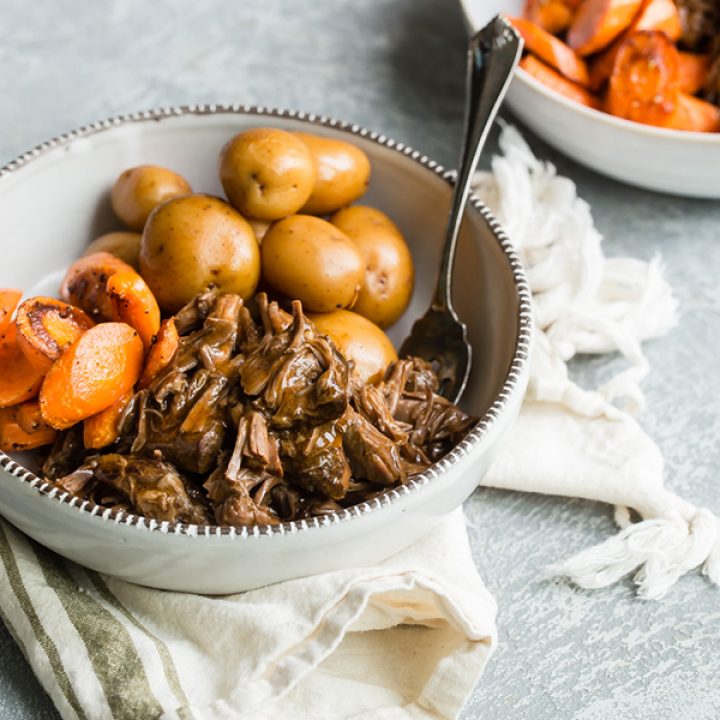 Pot Roast. potatoes and carrots served in a white bowl with fork