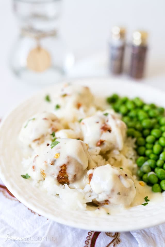plate of chicken Parmesan meatballs in creamy ranch sauce along with a side of peas