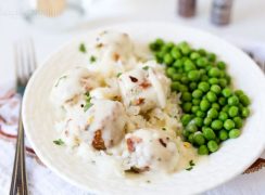 Pressure Cooker (Instant Pot) Chicken Parmesan Meatballs served a white plate with a side of peas