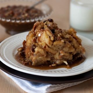 Pressure Cooker (Instant Pot) Cinnamon Raisin Bread Pudding with Caramel Pecan Sauce on a white plate