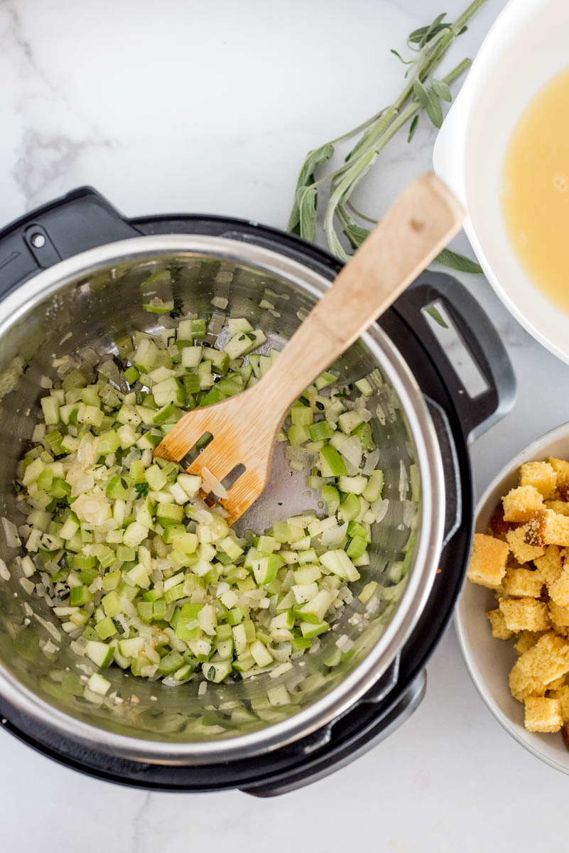Sautéing onions, celery, and green apples in an Instant Pot for cornbread dressing.