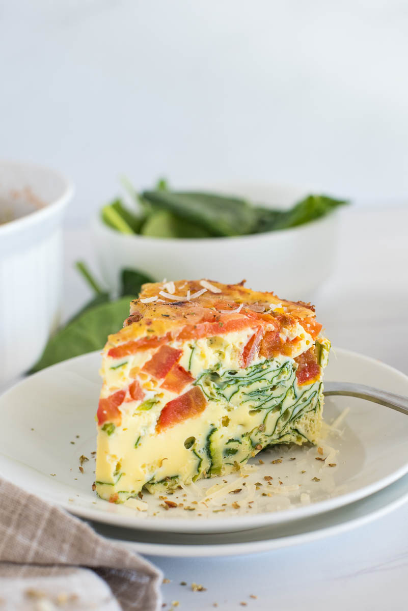 Close up of Instant Pot crustless spinach quiche topped with sliced tomatoes