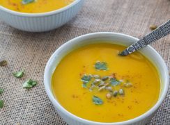 Pressure Cooker (Instant Pot) Curried Carrot Soup ready to eat in a white bowl with spoon in it.