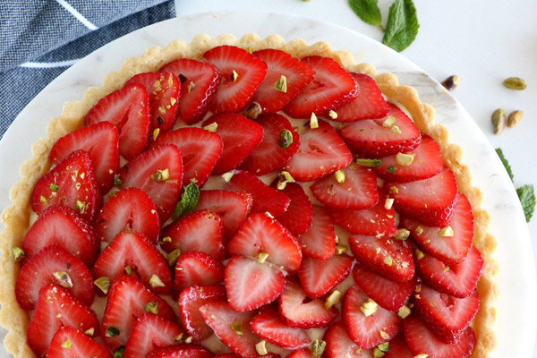 Del\'s Cooking Twist\'s Fresh Strawberry Tart with the strawberries sliced thin and spread out beautifully in overlapping circles across the top of the tart