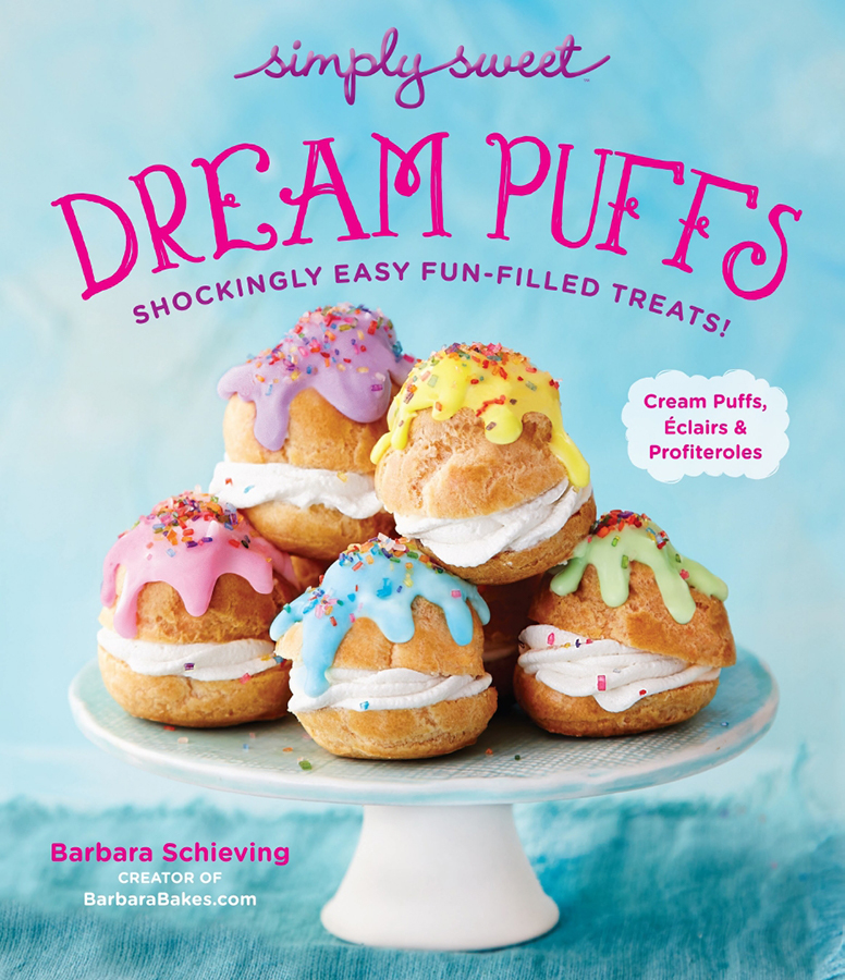 Front cover of Dream Puffs cookbook by Barbara Schieving, featuring a light blue background with a white cake stand loaded up with several cream puffs that have been topped with pastel rainbow colored glaze and rainbow sprinkles