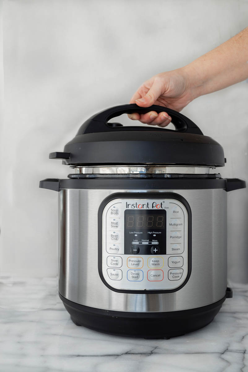 Lifting the lid off of an Instant Pot.