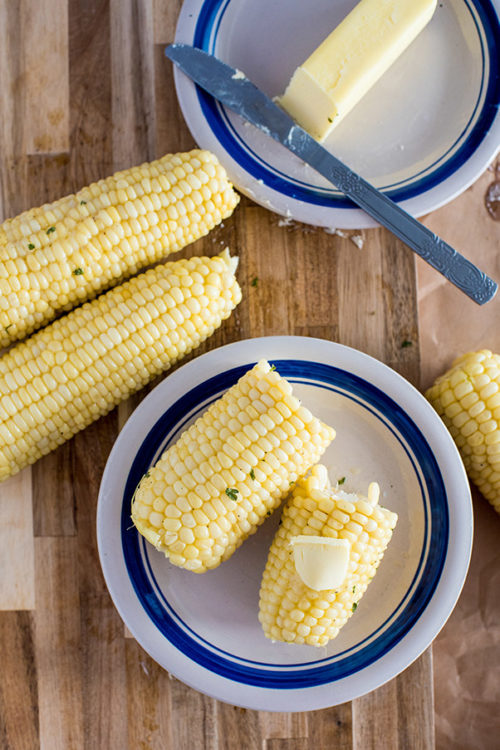 Corn on the cob cooked in the pressure cooker, plated and topped with butter, salt, and pepper