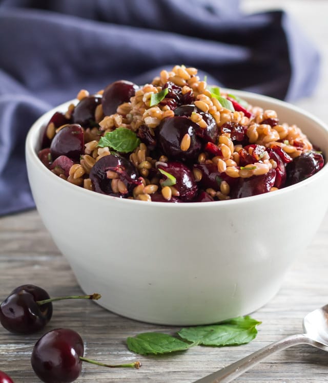 white serving bowl with Pressure Cooked Farro Salad with fresh cherries