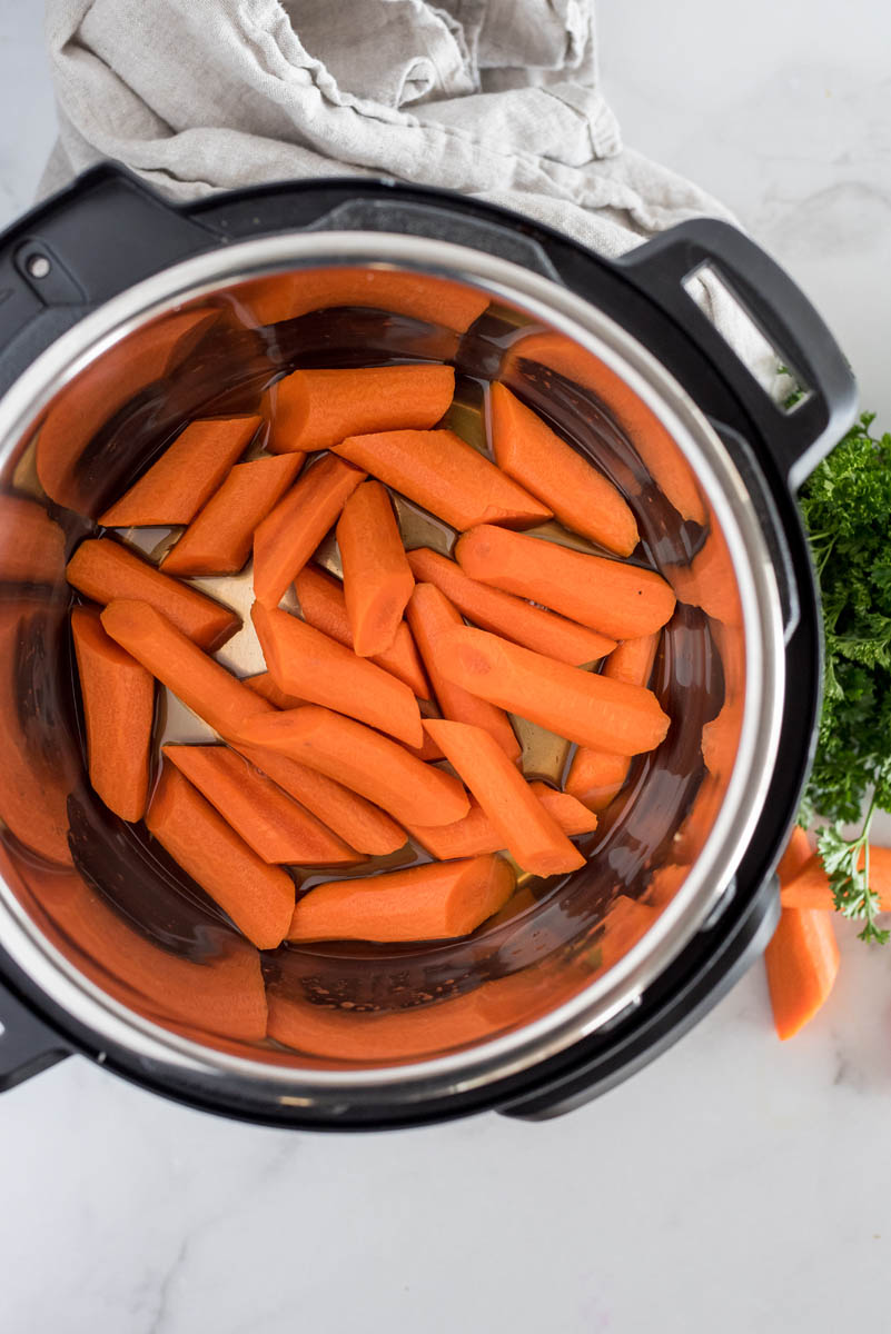 an overhead shot looking into an Instant Pot filled with diced carrots, cut into thick two inch pieces