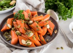 a 45 degree shot of Instant Pot glazed carrots, garnished with pepitas and pumpkin seeds and parsley