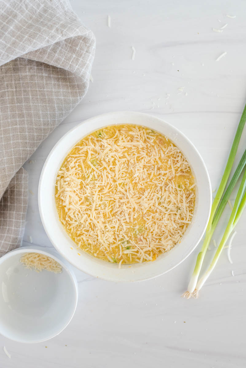 an overhead shot of a white ramekin with grated cheese sprinkled on top
