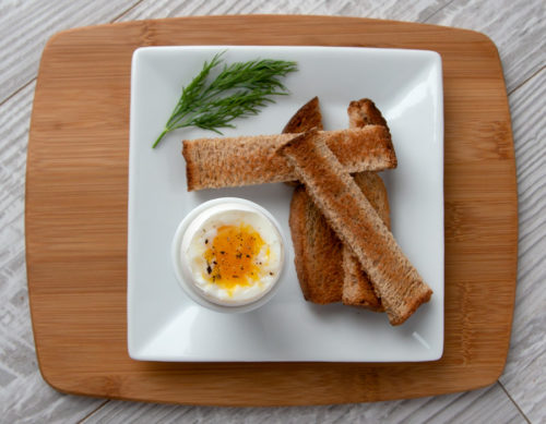 Soft-boiled egg in an egg cup plated with toast soldiers