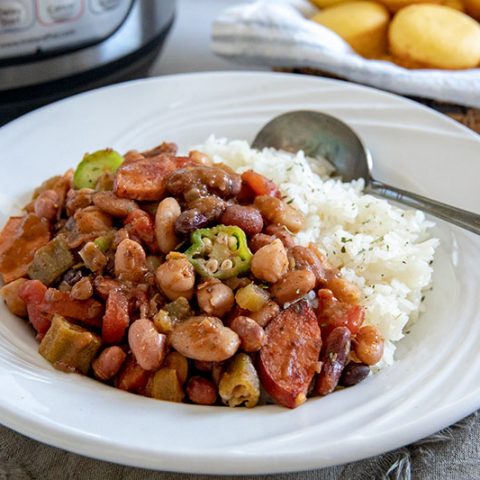 A bowl of Cajun 15 Bean Soup with sausage served over white rice