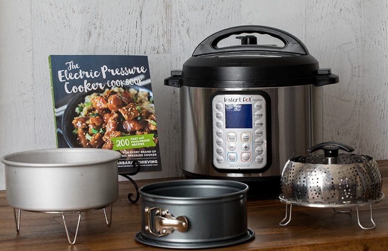 Electric Pressure Cooker Cookbook along with several of my favorite pressure cooking accessories (cake pan, trivet, springform, and steamer)