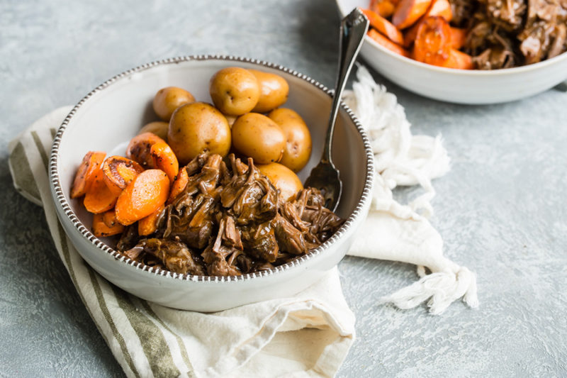 Instant Pot Pot Roast. potatoes and carrots served in a white bowl with fork