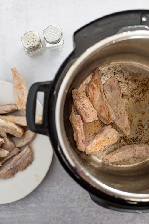 pork browning in the bottom of an Instant Pot
