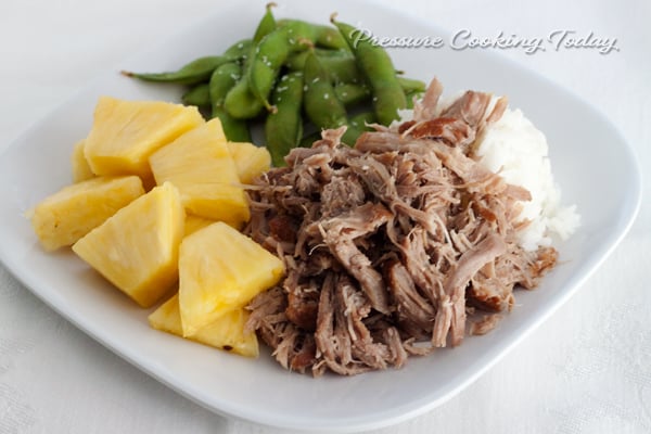 Pressure Cooker (Instant Pot) Kalua Pork on a white plate with pineapple chunks and snap peas 
