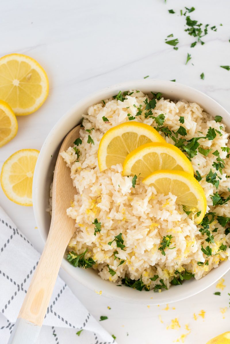 overhead of white bowl of instant pot lemon rice with fresh herbs