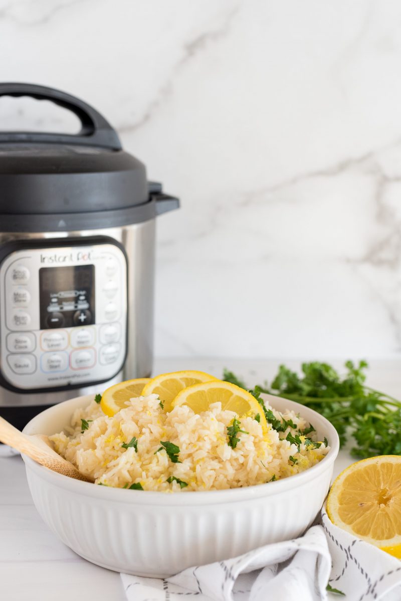 white bowl of lemon rice in front of an instant pot