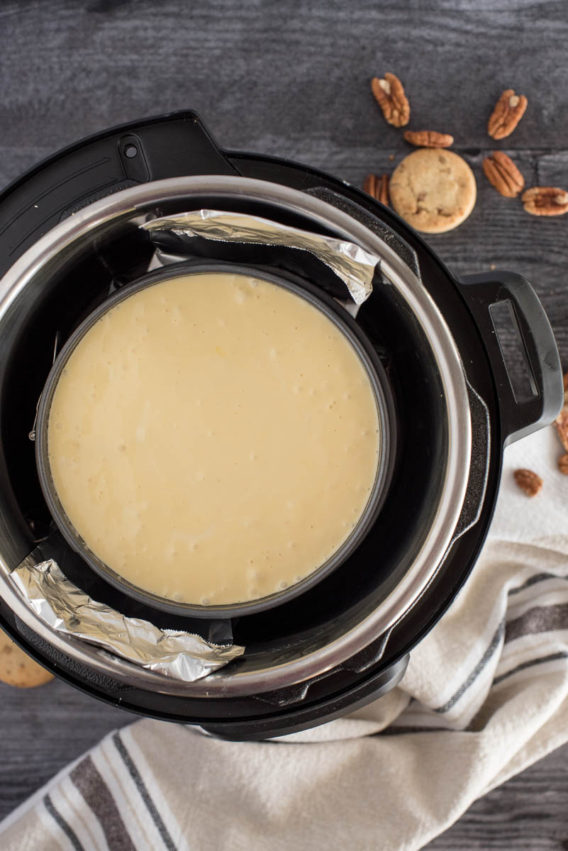 An overhead shot of New York cheesecake placed inside of an Instant Pot to cook.