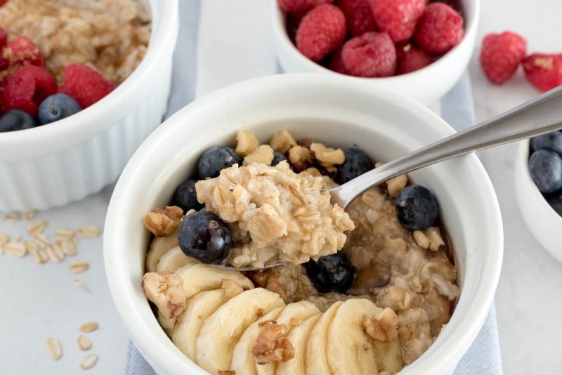 Close up shot of an Instant Pot oatmeal for one in a white bowl topped with granola, blueberries, and bananas.