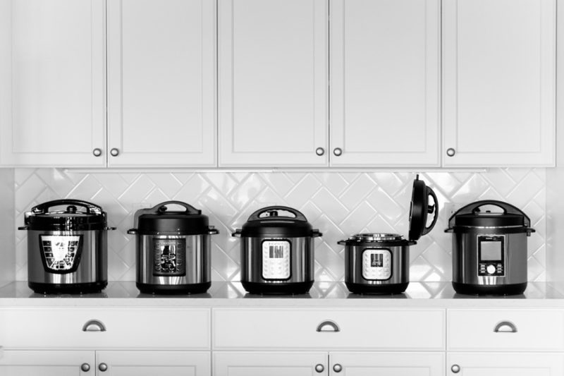5 different pressure cookers on a countertop including the Instant Pot