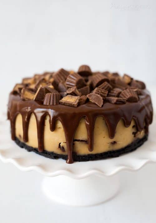 Pressure Cooker Peanut Butter Cup Cheesecake, topped with halved mini Reece\'s Peanut Butter Cups and drizzled chocolate ganache