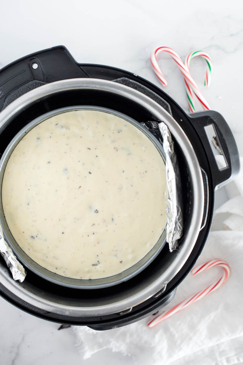 An overhead shot of Peppermint cheesecake batter going into the instant pot to cook in a springform pan