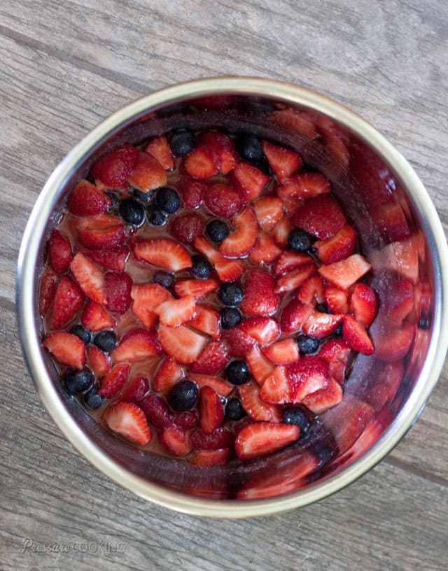 overhead shot of diced fresh strawberries and blueberries in a pressure cooker pot
