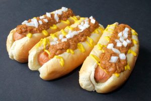 3 hot dogs in buns with Pressure-Cooker-Chili-Dog-Sauce