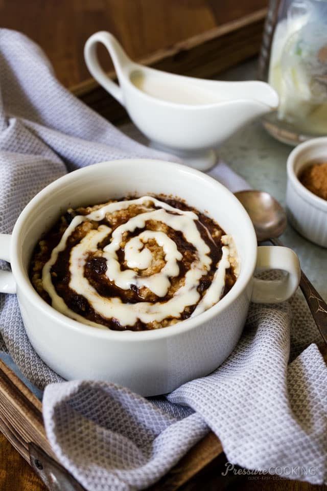 white dish of steel cut oats with cinnamon and a swirl of cream cheese frosting on top