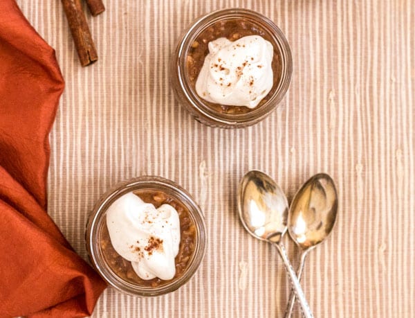 2 mason jars of pressure cooker pumpkin date brown rice pudding topped with dairy free whipped topping