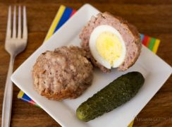Pressure Cooker (Instant Pot) Scotch Eggs on a white plate with a pickle