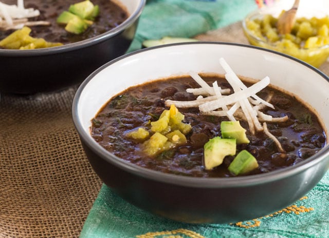 brown soup bowl filled with pressure cooker spicy black beans and hearty greens