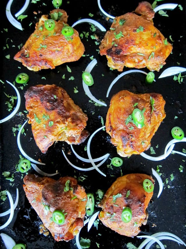 6 pieces of Pressure Cooker Tandoori Chicken garnished with raw onion and sliced jalapenos