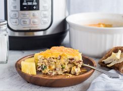 A slice of Pressure Cooker Meat Lovers Crustless Quiche, plated with an Instant Pot in the background
