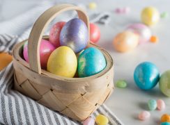 Pressure cooker hard boiled eggs dyed for Easter and placed in a basket with dyed eggs and jellybeans around it.