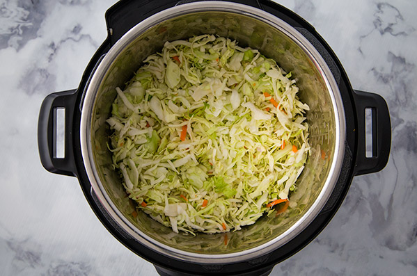 pressure cooking egg roll with cabbage on top in an Instant Pot