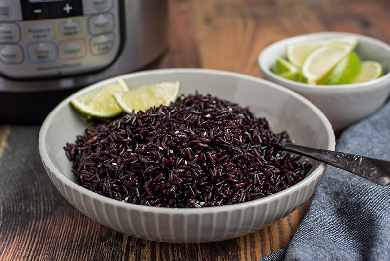 Pressure Cooker Black Rice prepared with limes and an Instant Pot in the background