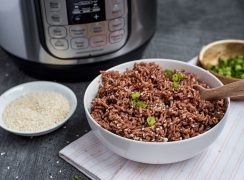 Pressure Cooker Pink Rice prepared with sesame seeds, chopped green onions, and an Instant Pot in the background