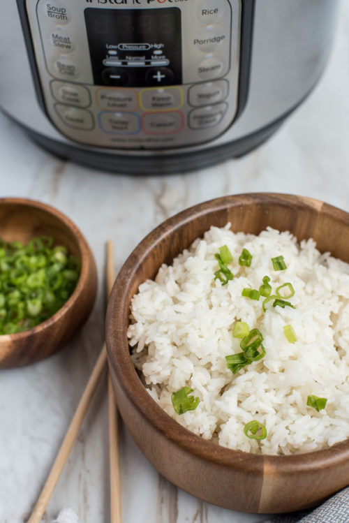 Pressure Cooker White Rice prepared with a green onion garnish and an Instant Pot in the background