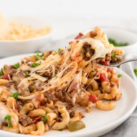 Instant pot american chop suey/beefaroni with melted cheese on a white dinner plate