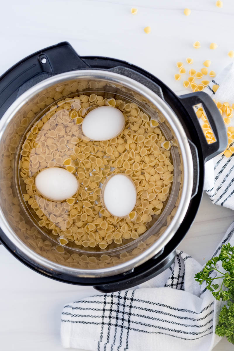 overhead of an instant pot with pasta and eggs