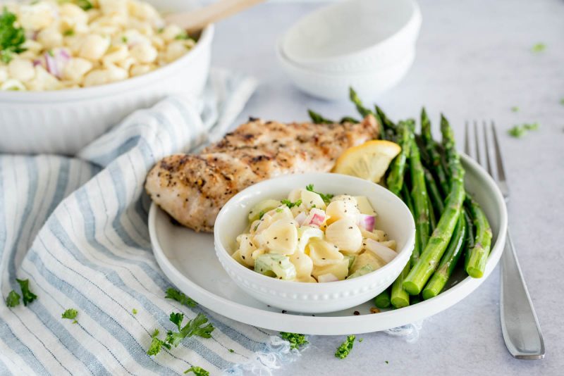 plate with pasta salad, asparagus and chicken breast