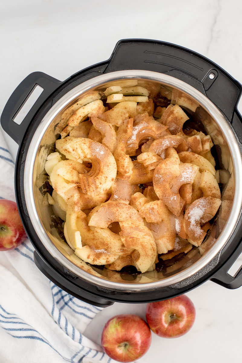 sliced apples in an electric pressure cooker for applesauce