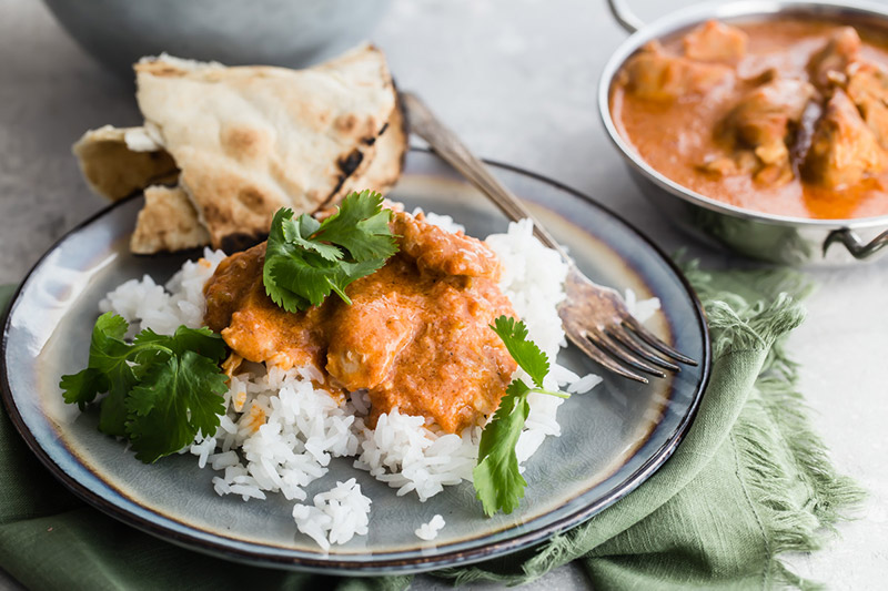 Pressure Cooker / Instant Pot Butter Chicken served on a bed of basmati rice with a side of naan