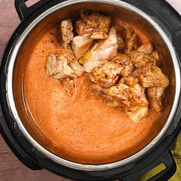 Indian Butter Chicken in the Instant Pot, with the browned chicken thighs on one side on top of the sauce